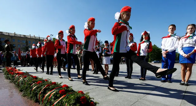 Belarusian schoolchildren, who are members of a pro-government Young Pioneer movement, take part in a meeting of the republican teams at the Victory square in Minsk, Belarus May 21, 2016. (Photo by Vasily Fedosenko/Reuters)
