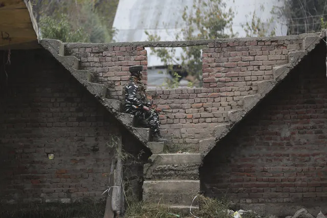 An Indian paramilitary soldier keeps guard near the site of an attack in Shopian, south of Srinagar, Indian controlled Kashmir, Friday, October 25, 2019. Gunmen on Thursday shot and killed an Indian truck driver and his attendant and wounded another driver as they fired at three vehicles laden with apple boxes in Indian-controlled Kashmir, police said. (Photo by Mukhtar Khan/AP Photo)