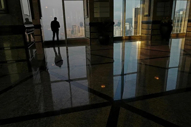 In this March 20, 2017 photo, a man looks at the Victoria Habour at a commercial building in Hong Kong. In the morning of Sunday, March 26, a select group of tycoons, business leaders, politicians and trade and industry group representatives will gather in a cavernous exhibition center to vote for the next leader of Hong Kong. Three candidates are on the ballot but there's little uncertainty about who the winner will be, with China's communist leaders already signaling early on their preference to the committee, which is stacked with pro-Beijing loyalists. (Photo by Vincent Yu/AP Photo)