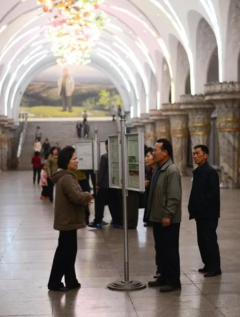 People read a communal newspaper in the Pyongyang subway system, which is claimed to be deep enough to double as a bomb shelter. (Photo by Gavin John/Mediadrumworld.com)