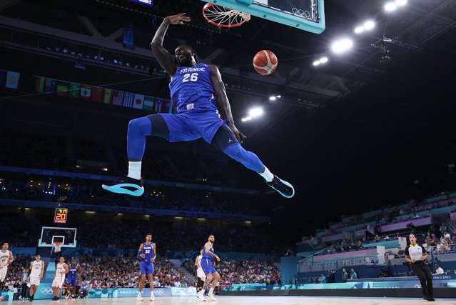 France's #26 Mathias Lessort dunks the ball in the men's preliminary round group B basketball match between Japan and France during the Paris 2024 Olympic Games at the Pierre-Mauroy stadium in Villeneuve-d'Ascq, northern France, on July 30, 2024. (Photo by Thomas Coex/AFP Photo)