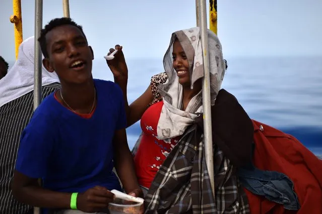 A couple of migrants share a meal aboard the rescue ship “Aquarius”, on May 25, 2016 a day after a rescue operation off the Libyan coast. The Aquarius is a former North Atlantic fisheries protection ship now used by humanitarians SOS Mediterranee and Medecins Sans Frontieres (Doctors without Borders) which patrols to rescue migrants and refugees trying to reach Europe crossing the Mediterranean sea aboard rubber boats or old fishing boat. (Photo by Gabriel Bouys/AFP Photo)