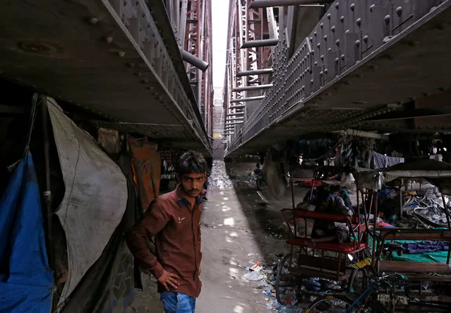 A man stands outside a makeshift cinema located under a bridge in the old quarters of Delhi, India May 25, 2016. (Photo by Cathal McNaughton/Reuters)
