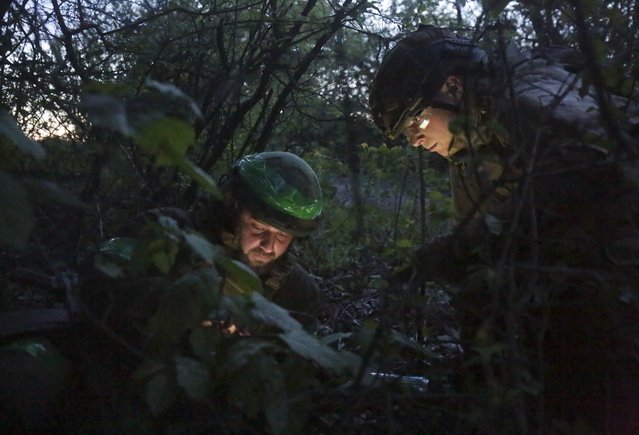 Ukrainian servicemen watch a map on their position near Kharkiv, Ukraine, 10 May 2022  amid the Russian invasion. Russian troops entered Ukraine on 24 February resulting in fighting and destruction in the country and triggering a series of severe economic sanctions on Russia by Western countries. According to the UNHCR on 09 May about 5,917,703 Ukrainians have left Ukraine to seek refuge in neighboring countries. Western countries have responded with various sets of sanctions against Russian state majority-owned companies and interests in a bid to bring an end to the conflict. (Photo by EPA/EFE/Stringer)