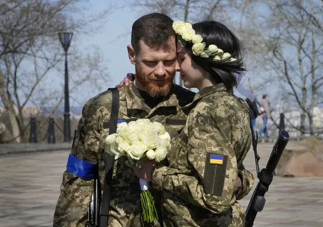 Ukrainian soldiers Anastasia and Vyacheslav embrace prior to their wedding ceremony in a city park in Kyiv, Ukraine, Thursday, April 7, 2022. (Photo by Efrem Lukatsky/AP Photo)