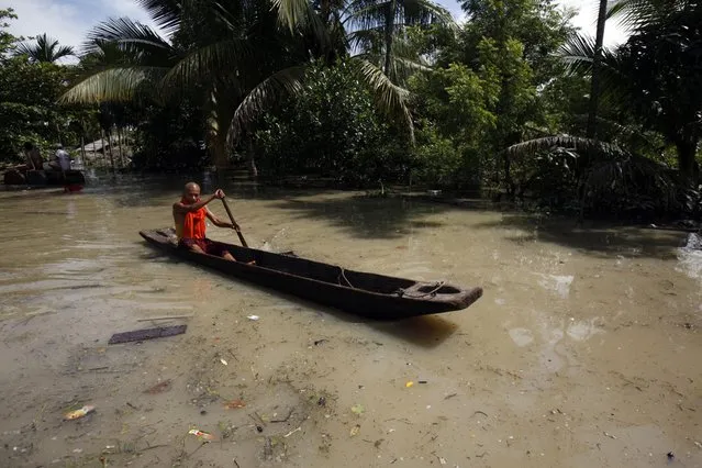 A Buddhist monk paddles a boat on a flooded road in Kalay township, northwestern Sagaing region, Myanmar, Sunday, August 2, 2015. (Photo by Khin Maung Win/AP Photo)