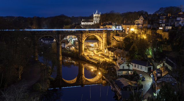 A train leaves a light trail as it crosses the viaduct over the River Nidd in Knaresborough in North Yorkshire, UK on January 12, 2024. (Photo by Andrew McCaren/London News Pictures)