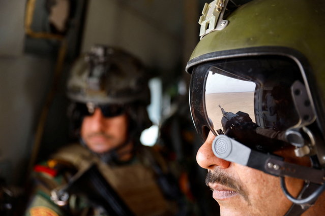 Iraqi Special Forces members sit inside a helicopter during the “Solid Will” military operation against Islamic State militants in the desert of Anbar, Iraq on April 23, 2022. (Photo by Thaier Al-Sudani/Reuters)