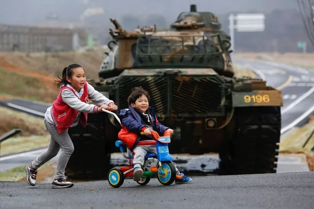 Children play in front of a tank on the island of Baengnyeong, which lies on the South Korean side of the Northern Limit Line (NLL), in the Yellow Sea April 12, 2014. (Photo by Damir Sagolj/Reuters)