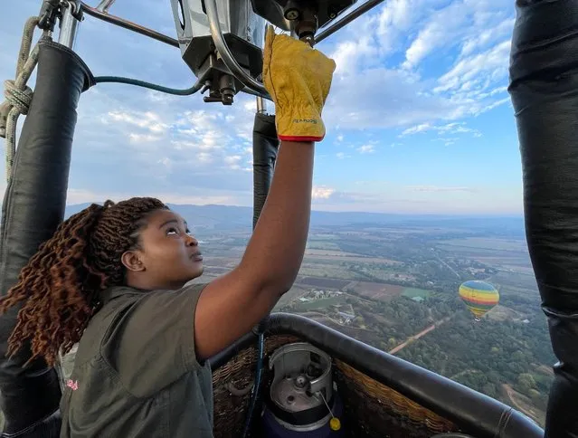 Semakaleng Mathebula, South Africa's first Black female hot-air balloon pilot releases propane gas into the burner of a hot-air balloon during a flight over Johannesburg, South Africa on May 15, 2022. (Photo by Sumaya Hisham/Reuters)