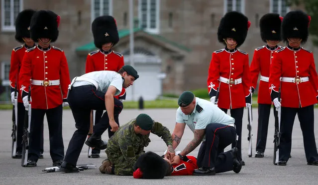 A member of the guard of honor is attended by colleagues after fainting prior to Mexico's President Enrique Pena Nieto's inspection at the Citadelle in Quebec City, Canada June 27, 2016. (Photo by Mathieu Belanger/Reuters)