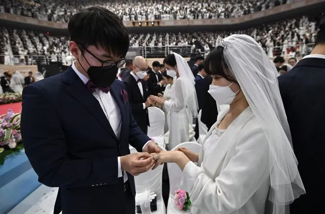 Couples wearing protective face masks attend a mass wedding ceremony organised by the Unification Church at Cheongshim Peace World Center in Gapyeong on February 7, 2020. South Korea has confirmed 24 cases of the SARS-like virus so far and placed nearly 260 people in quarantine for detailed checks amid growing public alarm. (Photo by Jung Yeon-je/AFP Photo)