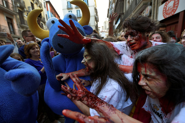 Revellers dressed as zombies bite a bull figure during an enactment of the running of the bulls a day before the start of the San Fermin festival in Pamplona, northern Spain, July 5, 2016. (Photo by Eloy Alonso/Reuters)