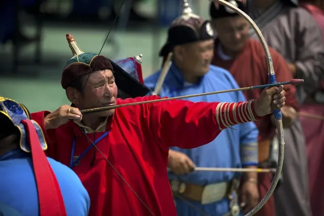 Mongolian men take part in an archery competition during the Naadam Festival in Ulaanbaatar, Mongolia, Monday, July 11, 2016. (Photo by Mark Schiefelbein/AP Photo)