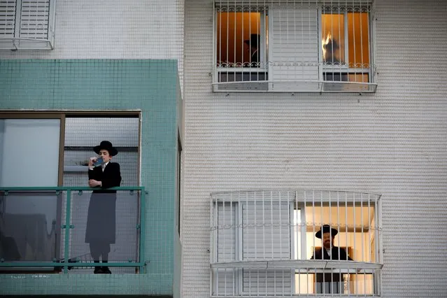 Jewish worshippers pray in their homes as they practice social distancing in keeping with government restrictions aimed at halting the spread of the coronavirus disease (COVID-19) in Ashdod, Israel on April 1, 2020. (Photo by Amir Cohen/Reuters)