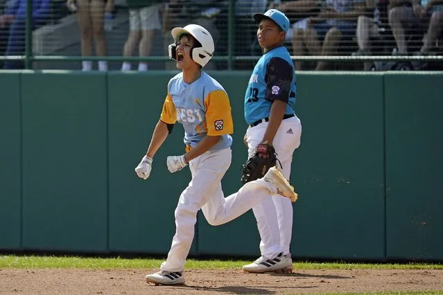 Honolulu's Kama Angell, left, celebrates as he rounds first base past Curacao's Kyshore Hinkel after hitting a solo home run during the first inning of the Little League World Series Championship game in South Williamsport, Pa., Sunday, August 28, 2022. (Photo by Gene J. Puskar/AP Photo)
