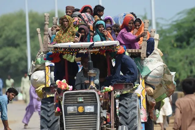 Displaced people arrive on a tractor with their belongings at a makeshift camp after fleeing from their flood hit homes following heavy monsoon rains in Sukkur, Sindh province on August 29, 2022. The death toll from monsoon flooding in Pakistan since June has reached 1,061, according to figures released on August 29, 2022, by the country's National Disaster Management Authority. (Photo by Asif Hassan/AFP Photo)