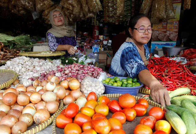 A vegetable seller serves a customer at a traditional market in south Jakarta, Indonesia August 1, 2016. (Photo by Iqro Rinaldi/Reuters)