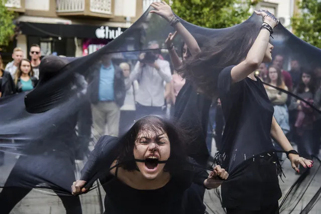 Women perform under black fabric during a street performance in Pristina on October 6, 2017 against sexual harassments in Kosovo. (Photo by Armend Nimani/AFP Photo)