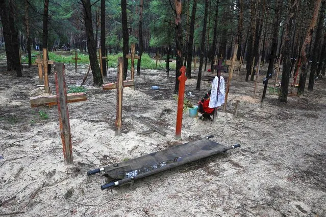 A photo shows crosses at a burial site in a forest on the outskirts of Izyum, on September 17, 2022. Ukraine said on September 17, 2022 it had counted 450 graves at just one burial site near Izyum after recapturing the eastern city from the Russians. (Photo by Juan Barreto/AFP Photo)