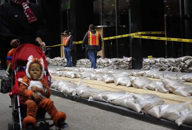 Sandbags are placed in front of No. 2 Broadway in Manhattan's Battery Park on Sunday. (Photo by Louis Lanzano/Associated Press)