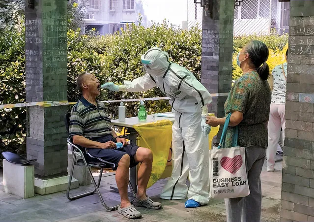 A man receives a nucleic acid test at a makeshift testing site in a residential compound after a new outbreak of the coronavirus disease (COVID-19) in Beijing, China on June 21, 2020. (Photo by Thomas Peter/Reuters)