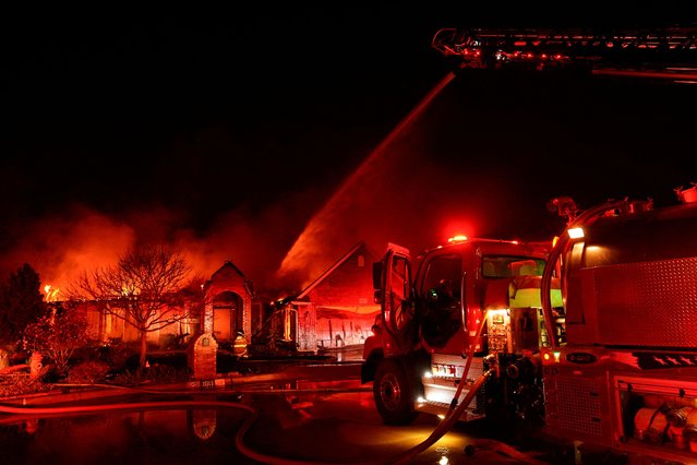 Firefighters battle a fire burning a house during a wildfire outbreak in Stillwater, Oklahoma, on March 14, 2025. (Photo by Nick Oxford/Reuters)