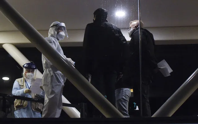 Passengers of the Buquebus ferry, right, go through a medical control checkpoint to disembark after docking in Montevideo, Uruguay, Friday, July 3, 2020. As Latin America struggles to contain coronavirus, Uruguay has managed to keep case numbers low, but in the last weeks reported new cases of COVID-19, two of them who arrived in a Buquebus from Argentina last week. (Photo by Matilde Campodonico/AP Photo)