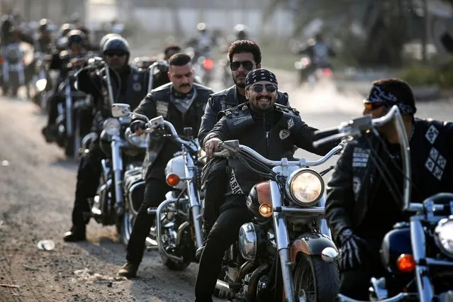 Members of Iraq's biker crew Bond Brothers MC take a break during a ride in the streets of the capital Baghdad on December 16, 2022. (Photo by Ahmad Al-Rubaye/AFP Photo)