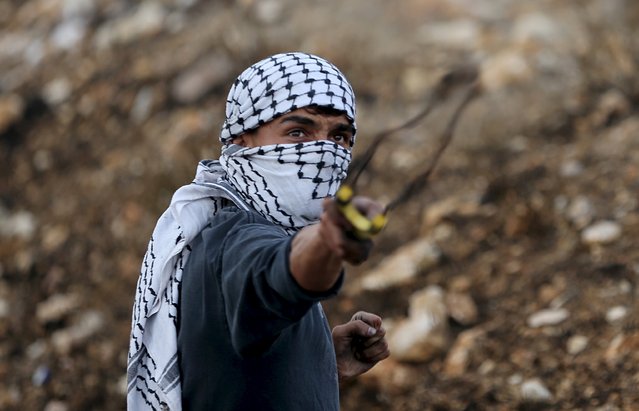 A Palestinian protester uses a slingshot to hurl stones towards Israeli troops during clashes near the Jewish settlement of Bet El, near the West Bank city of Ramallah October 7, 2015. (Photo by Mohamad Torokman/Reuters)