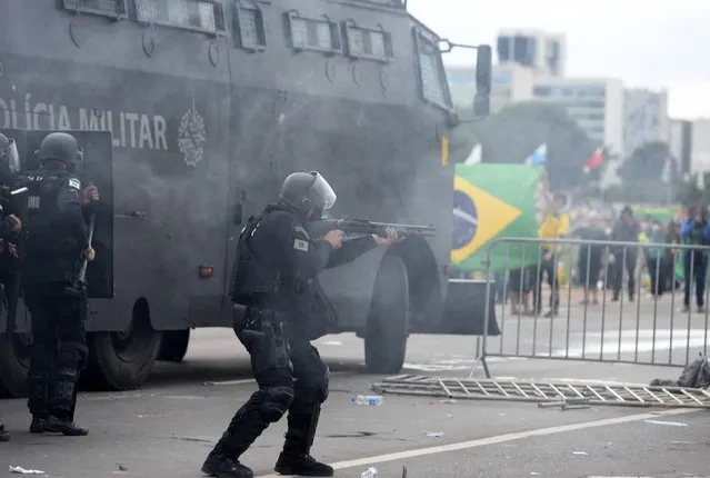 Security forces confront supporters of Brazilian former President Jair Bolsonaro invading Planalto Presidential Palace in Brasilia on January 8, 2023. Hundreds of supporters of Brazil's far-right ex-president Jair Bolsonaro broke through police barricades and stormed into Congress, the presidential palace and the Supreme Court Sunday, in a dramatic protest against President Luiz Inacio Lula da Silva's inauguration last week. (Photo by Ton Molina/AFP Photo)