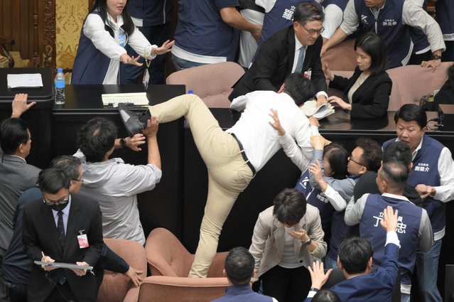 Taiwan's ruling Democratic Progressive Party (DPP) lawmaker Kuo Kuo Wen (C) tries jumping onto the desk during the voting for the Parliament reform bill at Parliament in Taipei on May 17, 2024. (Photo by Sam Yeh/AFP Photo)