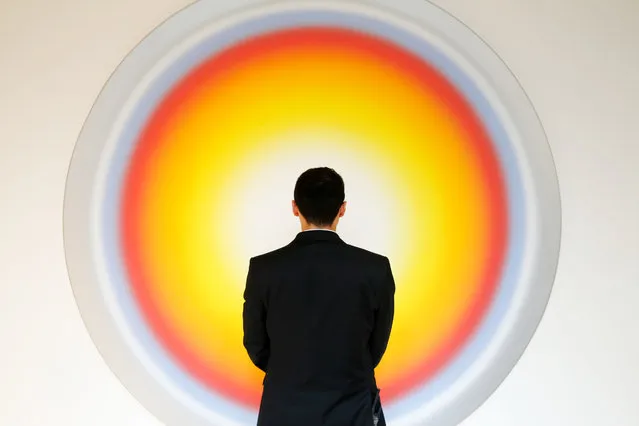 An employee stands in front of Ugo Rondinone's artwork "Nr.293 Siebterjanuarzweitausendunddrei" during a preview of A Visual Odyssey: Selections from LAC (Lambert Art Collection) at Ely House in this arranged photograph in London, U.K., on Monday, October 12, 2015. The collection, staged for exhibition by French interior designer Jacques Grange, will be sold at auction by Christie's International Plc in association with de Pury Pictet Turrettini & Cie SA, in London on Oct. 14. (Photo by Luke MacGregor/Bloomberg)