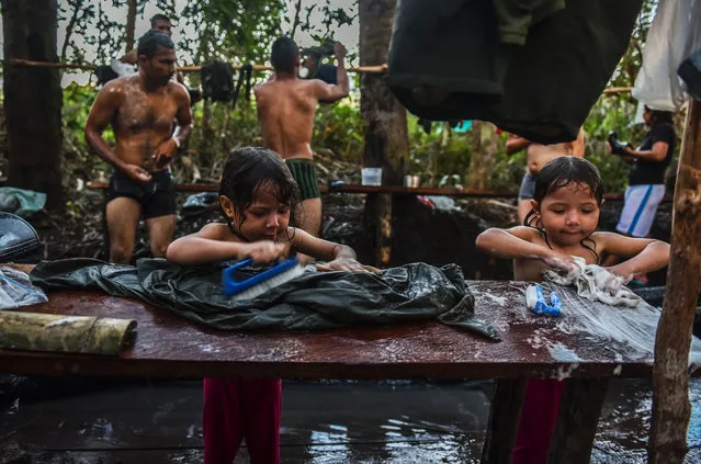 Children of Revolutionary Armed Forces of Colombia Members (FARC) wash clothes at the camp in Llanos del Yari, Caqueta department, Colombia, on September 20, 2016. After 52 years of armed conflict, FARC rebels open what leaders hope will be their last conference as a guerrilla army, where they are due to vote on a historic peace deal with the Colombian government. (Photo by Luis Acosta/AFP Photo)