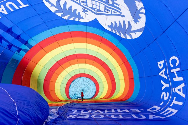 Balloonist Max Duncomb performs final checks before taking part in the 45th International Hot Air Balloon Festival in Chateau-d'Oex, Switzerland, on January 30, 2025. (Photo by Denis Balibouse/Reuters)