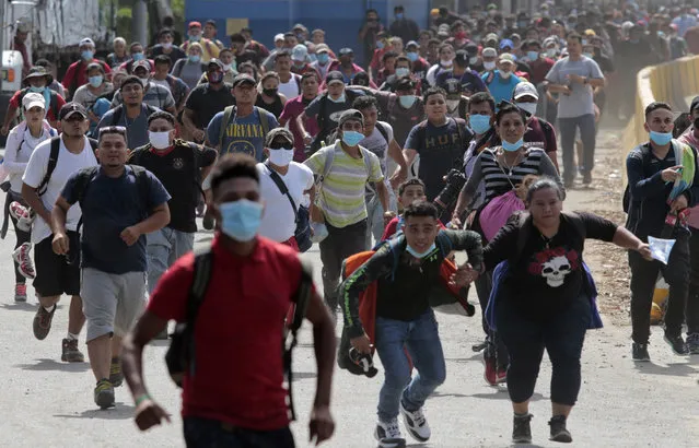 Migrants attempt to cross the border from Corinto, Honduras, into Corinto, Guatemala, Thursday, October 1, 2020. Hundreds of migrants walked from San Pedro Sula, Honduras to the Guatemala border, testing a well-trod migration route now in times of the new coronavirus. (Photo by AP Photo/Stringer)