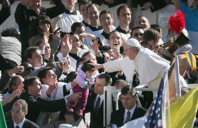 Pope Francis touches a child's head as he arrives in the Pope Mobile for his Inauguration Mass in St Peter's Square on March 19, 2013 in Vatican City, Vatican. The mass is being held in front of an expected crowd of up to one million pilgrims and faithful who have filled the square and the surrounding streets to see the former Cardinal of Buenos Aires officially take up his role as pontiff. Pope Francis' inauguration takes place in front of Cardinals and spiritual leaders as well as heads of state from around the world. (Photo by Peter Macdiarmid)