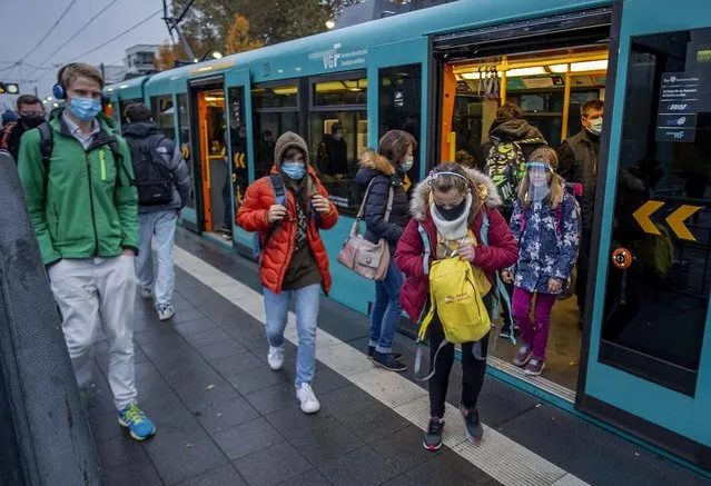 Students wear face masks as they leave a subway in Frankfurt, Germany, Wednesday, October 28, 2020. (Photo by Michael Probst/AP Photo)