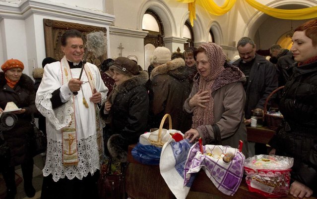 A Catholic priest blesses the faithful attending a service on the eve of Catholic Easter, in a church in Minsk March 30, 2013. (Photo by Vasily Fedosenko/Reuters)