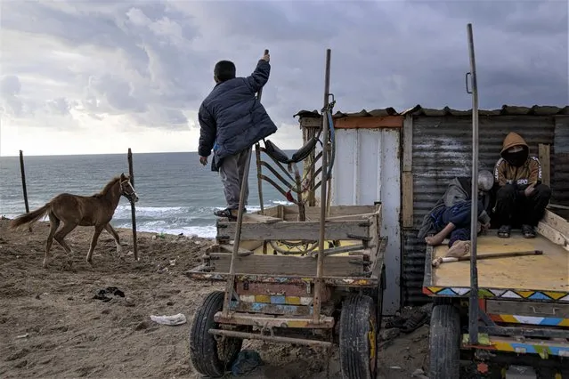 Palestinians sit in front of their house next to the beach during a rainy day in Dier al-Balah, central Gaza Strip, Saturday, February 4, 2023. (Photo by Fatima Shbair/AP Photo)