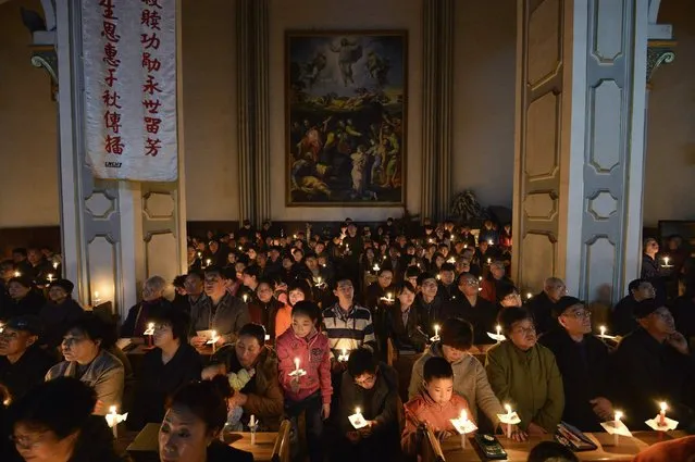 Worshippers hold candles during a mass on the eve of Easter, at a catholic church in Taiyuan, Shanxi province of China, on March 30, 2013. (Photo by Jon Woo/Reuters)