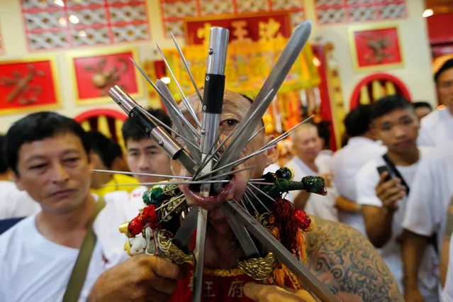 A devotee of the Chinese Bang Neow shrine with his face pierced takes part in a procession celebrating the annual vegetarian festival in Phuket, Thailand, October 6, 2016. (Photo by Jorge Silva/Reuters)