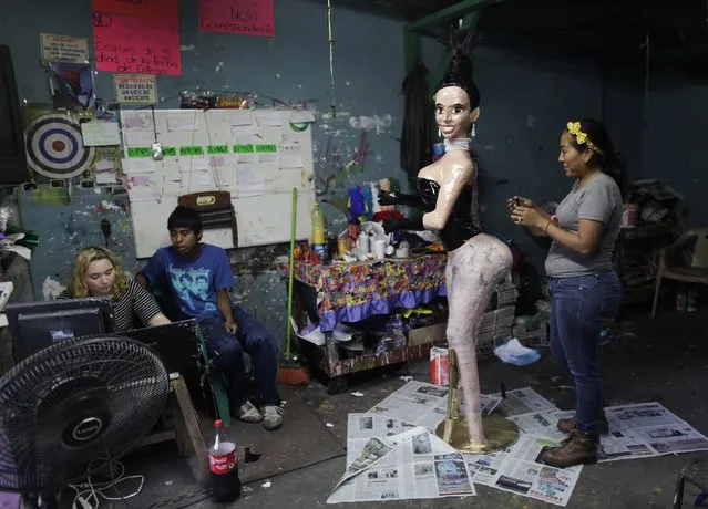 Adriana Ramirez (R) works on the outfit for a pinata depicting TV celebrity Kim Kardashian at her brother's workshop in Reynosa December 6, 2014. (Photo by Daniel Becerril/Reuters)