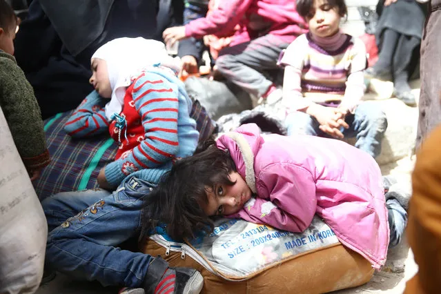 A girl looks at the camera during evacuations from the besieged town of Douma, Eastern Ghouta, in Damascus, Syria March 22, 2018. (Photo by Bassam Khabieh/Reuters)