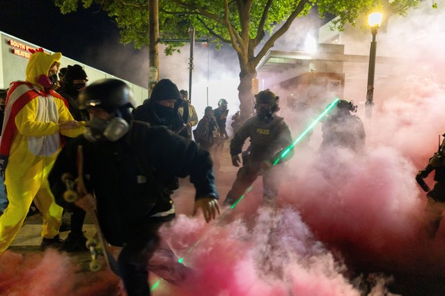 A protestor reacts as law enforcement officers deployed smoke grenades to disperse people gathered outside the U.S. Immigration and Customs Enforcement (ICE) headquarters in south Portland, Oregon, U.S., October 5, 2025. (Photo by Carlos Barria/Reuters)