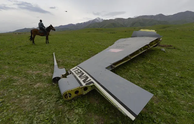 A U.S. Air Force KC-135 tanker aircraft wreckage is strewn across a field near the village of Chaldovar, about 100 miles (160 kms) west of the Kyrgyz capital Bishkek, Friday May 3, 2013. The emergencies ministry in Kyrgyzstan says a US military plane has crashed in the country. Kyrgyzstan hosts a US base that is used for troops transiting into and out of Afghanistan and for C-135 tanker planes that refuel warplanes in flight. (Photo by Vladimir Voronin/AP Photo)