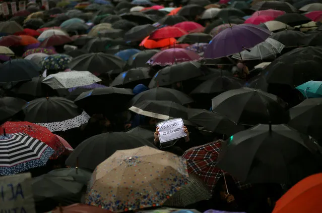 A woman holds up a sign that reads “We want us alive” amongst umbrellas during a demonstration to demand policies to prevent gender-related violence, in Buenos Aires, Argentina, October 19, 2016. (Photo by Marcos Brindicci/Reuters)