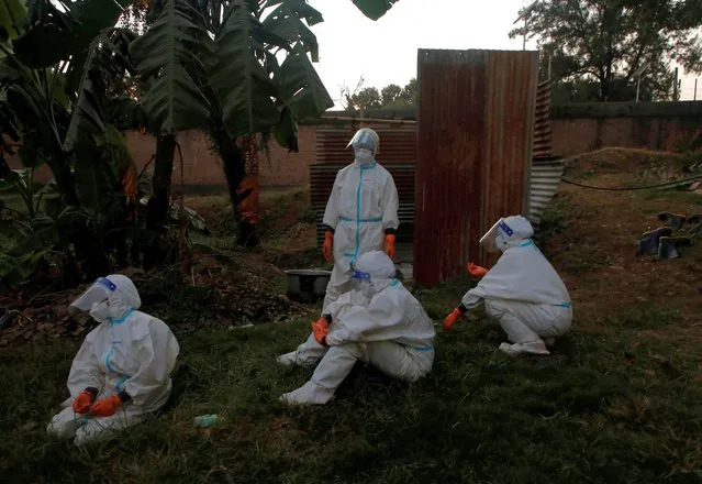 Female soldiers wearing personal protective equipment (PPE) take rest after handling bodies of coronavirus victims, amidst the spread of the coronavirus disease (COVID-19), in Kathmandu, Nepal on November 11, 2020. (Photo by Navesh Chitrakar/Reuters)