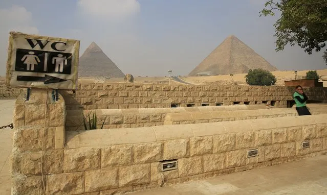 A woman waits in front of a toilet in front of the Sphinx at the Giza Pyramids on the outskirts of Cairo, Egypt, November 8, 2015. (Photo by Amr Abdallah Dalsh/Reuters)