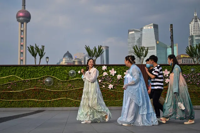 Young women wear traditional costumes while walking at the Bund along the Huangpu River in Shanghai on June 2, 2020. (Photo by Hector Retamal/AFP Photo)